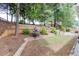 Terraced backyard with trees, landscaping, and a seating area at 2420 Walnut Grove Way, Suwanee, GA 30024