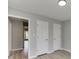 Bedroom showing multiple doors and light gray walls, complete with wood-look flooring at 2420 Walnut Grove Way, Suwanee, GA 30024