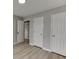 This bedroom features multiple closet doors, light gray walls, and wood-look flooring at 2420 Walnut Grove Way, Suwanee, GA 30024