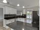Kitchen showcasing black countertops and modern stainless steel appliances at 2420 Walnut Grove Way, Suwanee, GA 30024
