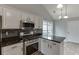 Kitchen view featuring stainless appliances and black countertops at 2420 Walnut Grove Way, Suwanee, GA 30024