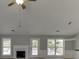 Cozy living room with bright white fireplace, ceiling fan, and abundant light from the backyard windows at 2420 Walnut Grove Way, Suwanee, GA 30024