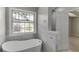 Bathroom featuring a freestanding tub, walk-in shower, and natural light from the large window at 2420 Walnut Grove Way, Suwanee, GA 30024