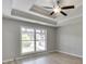 Spacious main bedroom featuring a tray ceiling with a ceiling fan and a large window at 2420 Walnut Grove Way, Suwanee, GA 30024