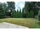 Large backyard with green grass, mature trees and a partial view of the patio at 1336 Nathan Mauldin Dr, Lawrenceville, GA 30043