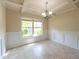 Elegant dining room features a tray ceiling, wainscoting, and a large window for natural light at 1336 Nathan Mauldin Dr, Lawrenceville, GA 30043