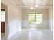 Formal dining room boasts wainscoting, tray ceiling, large window, and a stylish chandelier at 1336 Nathan Mauldin Dr, Lawrenceville, GA 30043