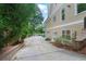 Side view of the home showcasing the long driveway, tan siding, and lush greenery at 2697 N Thompson Ne Rd, Atlanta, GA 30319