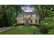 Charming two-story home featuring a manicured lawn and mature trees with the house lit at night, second story balcony at 2697 N Thompson Ne Rd, Atlanta, GA 30319