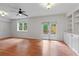 Bright living area featuring a ceiling fan, hardwood floors, built-in shelving, and access to the outdoor patio at 2697 N Thompson Ne Rd, Atlanta, GA 30319