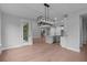 Bright dining room showcases modern chandelier, light walls, hardwood floors and leads to kitchen with center island at 4830 Briscoe Dr, Cumming, GA 30028
