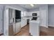 Modern kitchen with stainless steel refrigerator, white cabinets, island, and wood flooring at 5381 Briar Creek Ln, Norcross, GA 30071