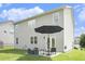 Back exterior of a two-story home with a well-maintained lawn and outdoor seating area at 7814 Messina Ct, Lithia Springs, GA 30122