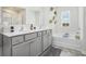 Bright bathroom featuring double vanity with gray cabinets, garden tub, and an accent wall with orchids at 7814 Messina Ct, Lithia Springs, GA 30122