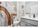 Bright bathroom featuring a modern vanity with gray cabinets and decorative shower curtain with an accent wall picture at 7814 Messina Ct, Lithia Springs, GA 30122