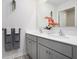 Bright bathroom featuring double vanity with gray cabinets, and an accent wall with orchid at 7814 Messina Ct, Lithia Springs, GA 30122