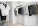 Walk-in closet with ample storage, featuring hanging rods with organized clothing at 7814 Messina Ct, Lithia Springs, GA 30122