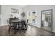 Dining area featuring modern black chairs, hardwood floors and a sliding glass doors to backyard at 7814 Messina Ct, Lithia Springs, GA 30122