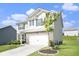 Two-story home featuring gray siding, a two-car garage, brick accents and a well-maintained front lawn at 7814 Messina Ct, Lithia Springs, GA 30122
