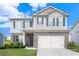 Charming two-story home with a brick and siding facade, manicured lawn, and attached two car garage at 7814 Messina Ct, Lithia Springs, GA 30122