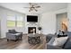 Living room featuring hardwood floors, a cozy fireplace, and a contemporary ceiling fan at 7814 Messina Ct, Lithia Springs, GA 30122