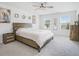 Bright main bedroom with neutral carpeting, three windows, a wood headboard, and decorative art at 7814 Messina Ct, Lithia Springs, GA 30122