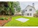 Large backyard featuring green lawn, mature trees, and a concrete patio at 98 Coopers Glen Sw Dr, Mableton, GA 30126