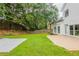 Spacious backyard with lush lawn, mature trees, a wooden fence and a concrete patio at 98 Coopers Glen Sw Dr, Mableton, GA 30126
