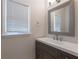Modern powder room featuring a gray vanity, granite counter and a decorative mirror at 98 Coopers Glen Sw Dr, Mableton, GA 30126
