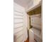 Compact laundry closet with a stacked washer and dryer unit and shelving at 230 E Ponce De Leon Ave # 324, Decatur, GA 30030