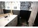 Bathroom featuring black and white feather wallpaper, black beadboard, and a modern sink at 3227 Due West Rd, Dallas, GA 30157