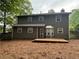 Backyard view of the two-story house featuring a wooden deck and fenced in yard at 525 Cherokee Overlook Ct, Canton, GA 30115