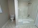 This bathroom includes a combination bathtub and shower with a white toilet at 525 Cherokee Overlook Ct, Canton, GA 30115