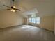 Spacious carpeted bedroom with high ceilings, a ceiling fan, and plenty of natural light from the windows at 525 Cherokee Overlook Ct, Canton, GA 30115