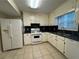 Well-lit kitchen with white appliances, cabinets, and a view of the window at 525 Cherokee Overlook Ct, Canton, GA 30115
