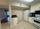 Efficient kitchen with tiled floor, white cabinets, appliances, and dark counter tops at 525 Cherokee Overlook Ct, Canton, GA 30115