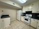 Cozy kitchen with white cabinets, appliances, tiled floors, and a spacious layout at 525 Cherokee Overlook Ct, Canton, GA 30115