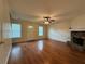 Open-concept living room featuring hardwood floors, a stone fireplace, and natural light at 525 Cherokee Overlook Ct, Canton, GA 30115