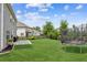 Spacious backyard with lush green grass, black fence and an in-ground trampoline at 6825 Rambling Vale, Cumming, GA 30028