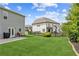 Expansive backyard with manicured lawn, concrete patio, and black fencing, ideal for recreation at 6825 Rambling Vale, Cumming, GA 30028