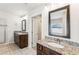 Dual vanity bathroom with granite counters, framed mirrors, and tiled flooring at 6825 Rambling Vale, Cumming, GA 30028