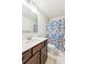 Bathroom featuring single sink vanity, updated fixtures and shower with a patterned curtain at 6825 Rambling Vale, Cumming, GA 30028