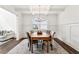 Dining room featuring an elegant light fixture, hardwood flooring, and beautiful wainscoting at 6825 Rambling Vale, Cumming, GA 30028