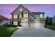Charming two-story home with a brick facade, a three-car garage, and manicured front lawn at 6825 Rambling Vale, Cumming, GA 30028