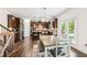 Open-concept kitchen with dark wood cabinets, stainless steel appliances, and a dining area with natural light at 6825 Rambling Vale, Cumming, GA 30028