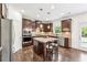 Modern kitchen with stainless steel appliances, wooden cabinets, granite countertops, and an island with seating at 6825 Rambling Vale, Cumming, GA 30028