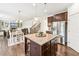 Kitchen island and stainless steel refrigerator adjacent to a dining and living area with fireplace at 6825 Rambling Vale, Cumming, GA 30028