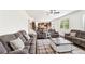 Spacious living room with plush sofas, a coffee table, and view of the kitchen and staircase at 6825 Rambling Vale, Cumming, GA 30028