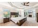 Main bedroom with carpeting, large bed, fan, and a view of the fireplace at 6825 Rambling Vale, Cumming, GA 30028