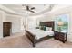 Main bedroom with carpeting, large bed, tray ceiling, windows and ensuite bath at 6825 Rambling Vale, Cumming, GA 30028